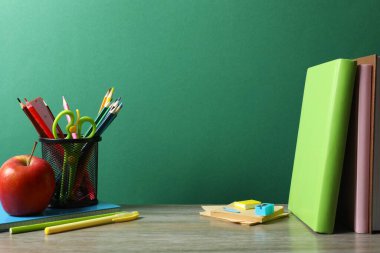 Okula dönelim. Renkli kağıda yakın çekim, yeşil karatahta üzerine ders kitapları