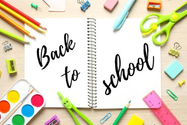 Okul kırtasiyesi ve ahşap zemin üzerinde açık bir defter ile düz yatıyordu, üst görünüm