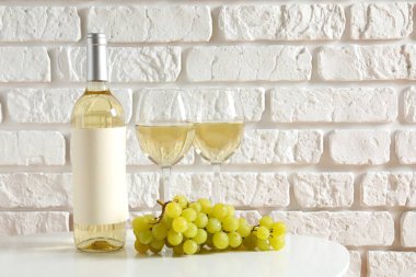 Masada üzüm ve bardak ile bir şişe beyaz şarap.