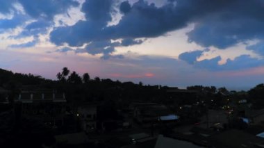 Alacakaranlık zamanı, deniz manzaralı gün batımı, kara bulutlar, kırmızı gökyüzü. Hızlı geçen arabalar, gün batımı gökyüzü, ufuk, Tayland Phuket 'in güzel doğası, bulutlu gün batımı. Yüksek kalite 4k görüntü