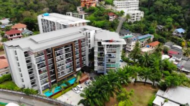 Phuket 'te konaklama, güzel doğa otelleri, havuz ve otel alanları. Hava fotoğrafçılığı, turizm, güzel yeşil doğa, tepeler ve dağlar, yol, modern oteller ve tatil köyleri. Yüksek kalite 4k
