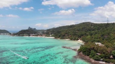 Phi Phi adaları, hava manzarası, geçen tekne, sahil şeridi, yeşil tropikal orman. Çok temiz su, turkuaz renk, güneşli hava, gökyüzü, sürat teknesi turizmi, turizm. Yüksek kalite 4k görüntü