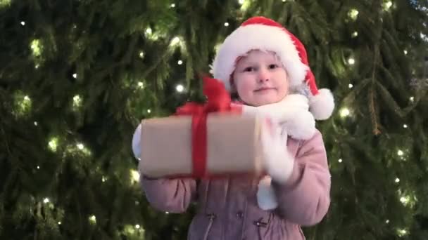 Ευτυχισμένο Κοριτσάκι Στο Καπέλο Σάντα Κουτί Των Χριστουγέννων Δίνει Ένα — Αρχείο Βίντεο