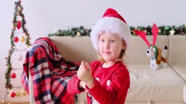 Noel Baba Şapkalı Gülümseyen Çocuk Dans Ediyor Kameraya Bakarken Eğleniyor — Stok video