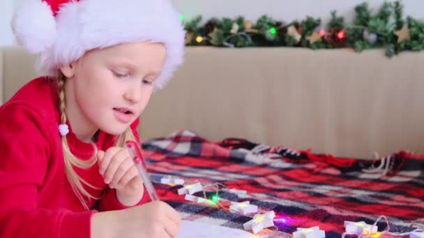 Gelukkig Klein Meisje Kerstman Hoed Ligt Bed Thuis Het Schrijven — Stockvideo