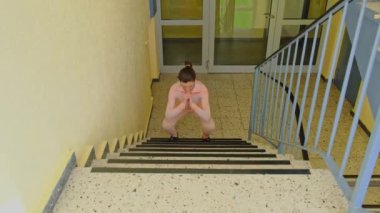 crouch and jump up sports stairs emergency multi-storey building athlete girl.Healthy, wellness lifestyle. Sport and cardio workout concept.