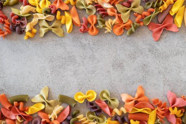 Variety of types and shapes of Italian pasta on concrete background. Italian cuisine food concept and menu design. Dry pasta background. Top view. Flat lay. Copy space.