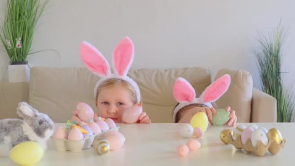 Дві Маленькі Сестрички Кролячих Вухах Прикріплюють Голову Під Столу Дивляться — стокове відео