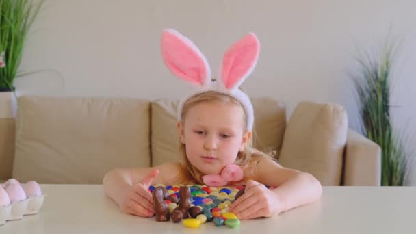 Mała Blondynka Królicze Uszy Znaleziono Lubi Czekoladki Cukierki Jajka Stole — Wideo stockowe