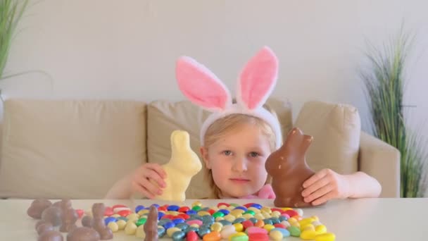 Blondynka Wielkanocnymi Uszami Bawiąca Się Czekoladą Przy Stole Domu Wielkanoc — Wideo stockowe