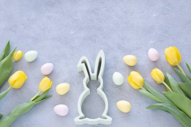 Renkli paskalya yumurtaları ve beton zemin üzerinde tavşan olan güzel sarı laleler. Fotokopi alanı olan bahar ve Paskalya bayramı kavramı.