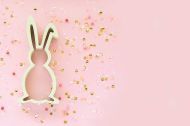 Tavşanlı Paskalya süslemesi ve pembe arka planda konfeti. Yaratıcı bahar tatili konsepti. Boşluğu kopyala