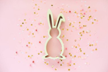 Tavşanlı Paskalya süslemesi ve pembe arka planda konfeti. Yaratıcı bahar tatili konsepti.