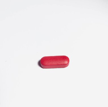 Kırmızı hap hapları beyaz arka planda izole edilmiş. Tek bir ilaç.