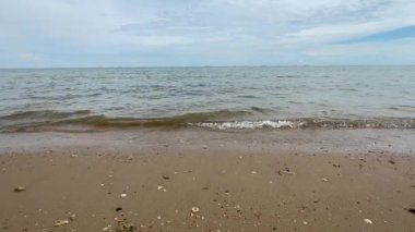 Deniz. Kumsal. Kum. Gökyüzü. Sahildeki dalganın sesi. Yaz günü deniz manzaralı sahiller. El salla. Plaj metin alanı