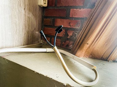 Elektrik kablosunun ucu hasar görmüş ve sadece koli bandıyla kapatılmış.