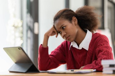 Dijital tablet kullanan stresli genç zenci kadın portresi