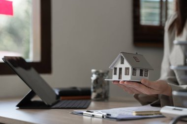 Emlakçı ve müşteri ev, sigorta ya da kredi emlak geçmişi sözleşmesi için tartışıyorlar.