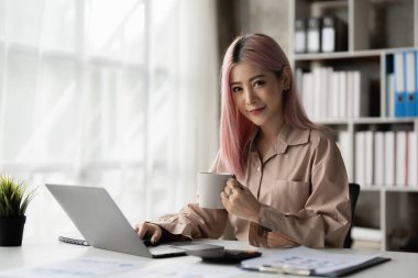 Asyalı İş kadını, cep telefonuyla konuşan iş ekibiyle teknik fiyat grafiğini ve göstergeyi analiz etmeye çalışıyor. Hesap ya da tasarruf parası ya da sigorta kavramı.