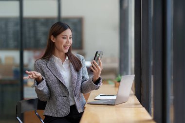 Mutlu Asyalı kadın portresi cep telefonuyla arkadaşıyla konuşuyor..