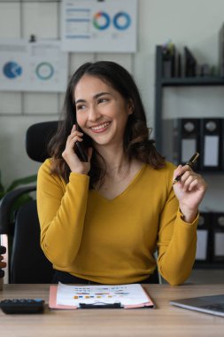 Ofiste telefonla konuşan Asyalı zeki bir iş kadını. Gayrimenkul, avukat, kar amacı gütmeyen, pazarlama.