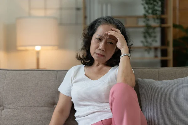 Depressed Elderly Asian woman sitting alone at home. Retired woman concept