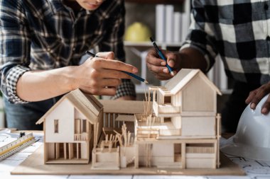 Mimarlık planının planlarıyla çalışan mimar takımı, bir inşaat projesi çizen mühendis, yeşil enerji konsepti.