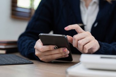 İş kadını cep telefonunda banka tasarruf hesabı başvurusu, hesap ya da tasarruf hesabı ya da sigorta kavramı var.