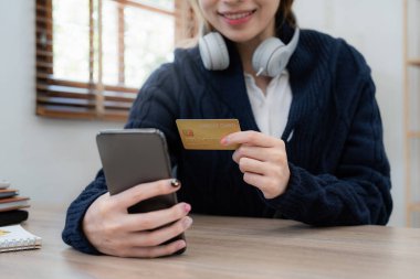 Young person using credit card and laptop computer. Online shopping, e-commerce concept.