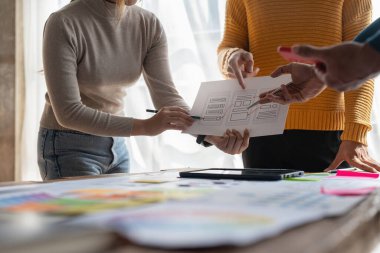 Bir grup ux geliştirici ve ui tasarımcı modern ofisteki uygulama arayüzü tasarımı hakkında beyin fırtınası yapıyorlar. Yaratıcı dijital geliştirme ajansı.