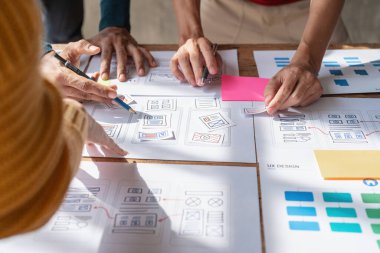 Bir grup ux geliştirici ve ui tasarımcı modern ofisteki uygulama arayüzü tasarımı hakkında beyin fırtınası yapıyorlar. Yaratıcı dijital geliştirme ajansı.