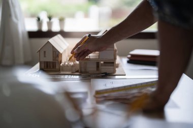 Mimarlık planının planlarıyla çalışan mimar, bir inşaat projesi çizen mühendis, yeşil enerji kavramı.