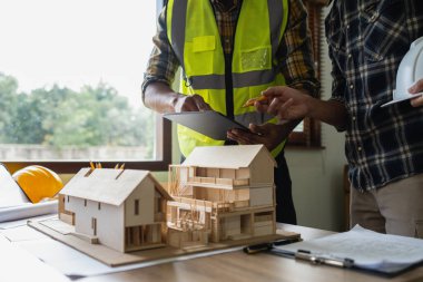 Mimarlık planının planlarıyla çalışan mimar takımı, bir inşaat projesi çizen mühendis, yeşil enerji konsepti.