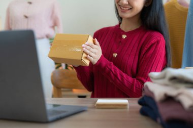 Serbest Asyalı Kadın Girişimcisi olarak açılışta kutulu bir dizüstü bilgisayar kullanarak online pazarlama paketleme kutusu ve KOBİ fikir konseptini dağıtma başarısı.