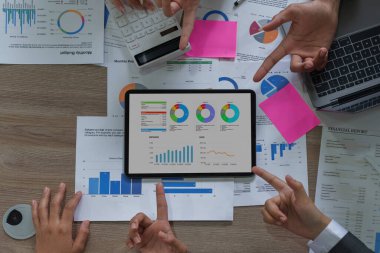 Fon yöneticisi ve muhasebeci grubu, yolsuzluk hesabının soruşturulması için dijital tablet üzerindeki veri belgelerini kontrol ediyor .