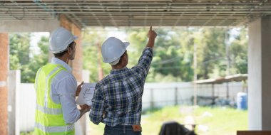 Mimarlık planının planlarıyla çalışan mimar takımı, bir inşaat projesi çizen mühendis, yeşil enerji konsepti.