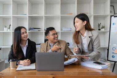 İşletme danışmanı grubu büyük veriler üzerinde çalışıyor ve şirketin mali belgelerini analiz ediyor.