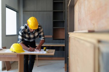 Mimarlık planının planlarıyla çalışan mimar, bir inşaat projesi çizen mühendis, yeşil enerji kavramı.