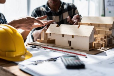 Mimarlık planının planlarıyla çalışan mimar takımı, bir inşaat projesi çizen mühendis, yeşil enerji konsepti.