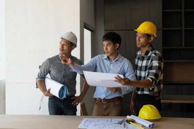 Mimarlık planının planlarıyla çalışan mimar takımı, bir inşaat projesi çizen mühendis, yeşil enerji konsepti.