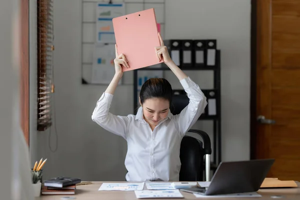 Stressed Asian business woman worry with many document on desk at office. Businesswoman working at home.