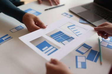 Bir grup ux geliştirici ve ui tasarımcı modern ofisteki uygulama arayüzü tasarımı hakkında beyin fırtınası yapıyorlar. Yaratıcı dijital geliştirme ajansı.