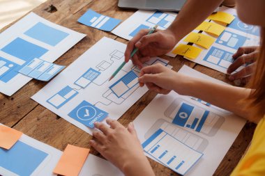 Bir grup ux geliştirici ve ui tasarımcı modern ofisteki uygulama arayüzü tasarımı hakkında beyin fırtınası yapıyorlar. Yaratıcı dijital geliştirme ajansı.