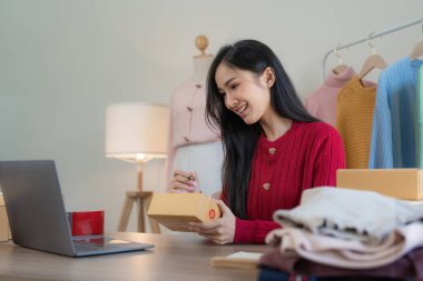 Serbest Asyalı Kadın Girişimcisi olarak açılışta kutulu bir dizüstü bilgisayar kullanarak online pazarlama paketleme kutusu ve KOBİ fikir konseptini dağıtma başarısı.