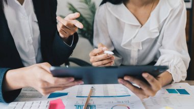 Fon yöneticileri takım danışmanlığı ve dijital tablet üzerinden yatırım borsası analizi hakkında tartışmalar.