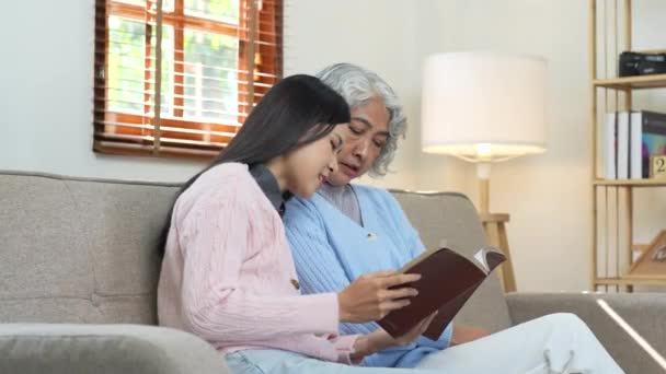 Kochająca Dorosła Córka Czytająca Książki Starsza Matka Domu Rodzina Azjatki — Wideo stockowe