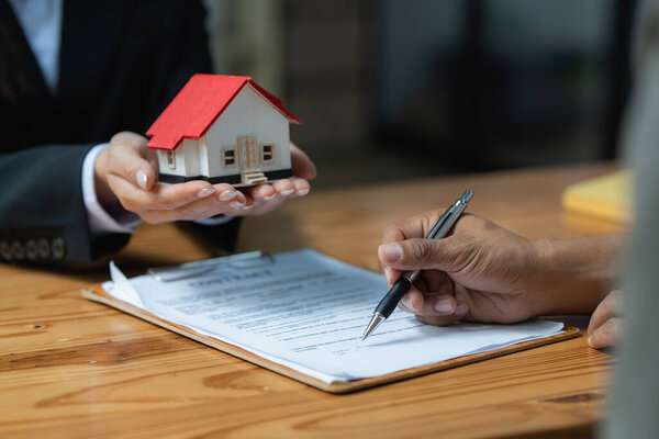 Close up Business woman or Real Estate agent explain signing agreement for buying house. Bank manager and real estate concept.