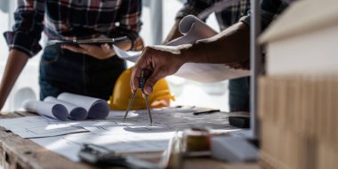 Mimarlık planının planlarıyla çalışan mimar takımı, bir inşaat projesi çizen mühendis, yeşil enerji konsepti.