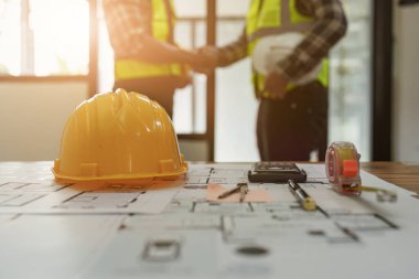 Mimar ve mühendis inşaat işçileri ofis inşaatındaki bir anlaşmayı bitirdikten sonra el sıkışıyorlar, başarı işbirliği konsepti.