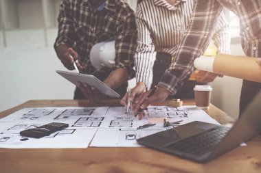 Profesyonel mimar tasarımcı yapı mühendisi takım arkadaşları bina tasarım projesini tartışıyor.